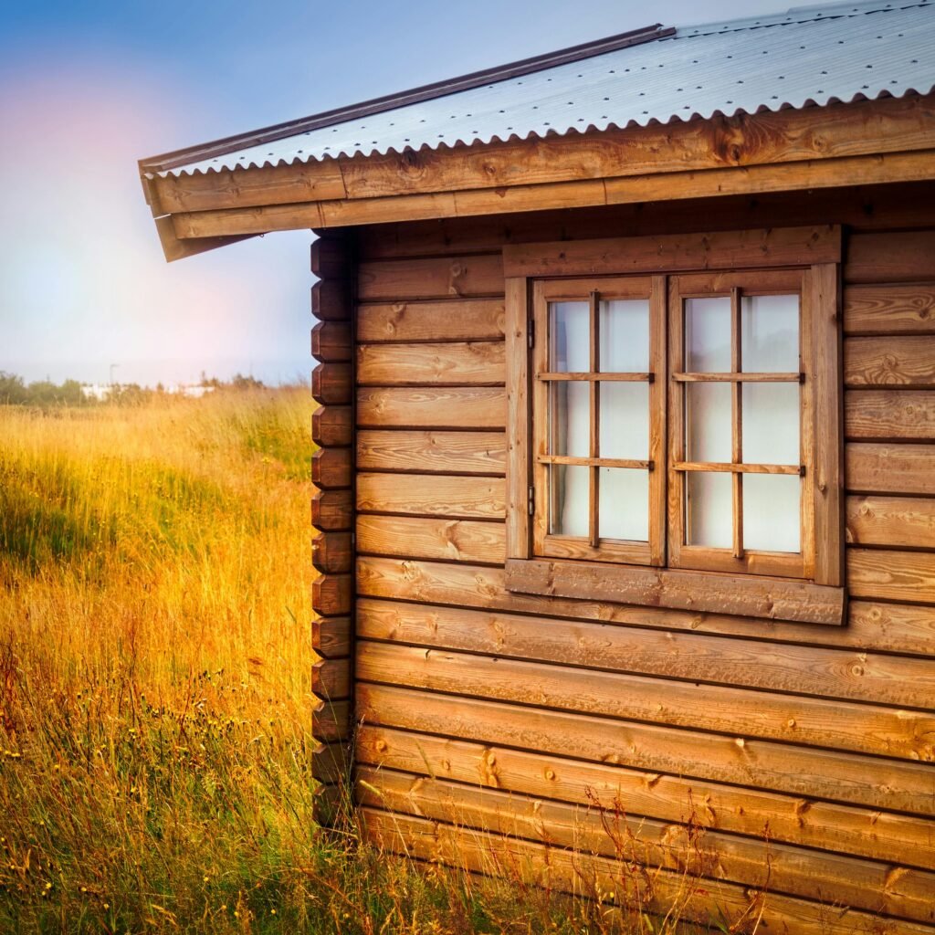 A quaint wooden cabin with rustic charm, nestled in a serene rural setting during summer.